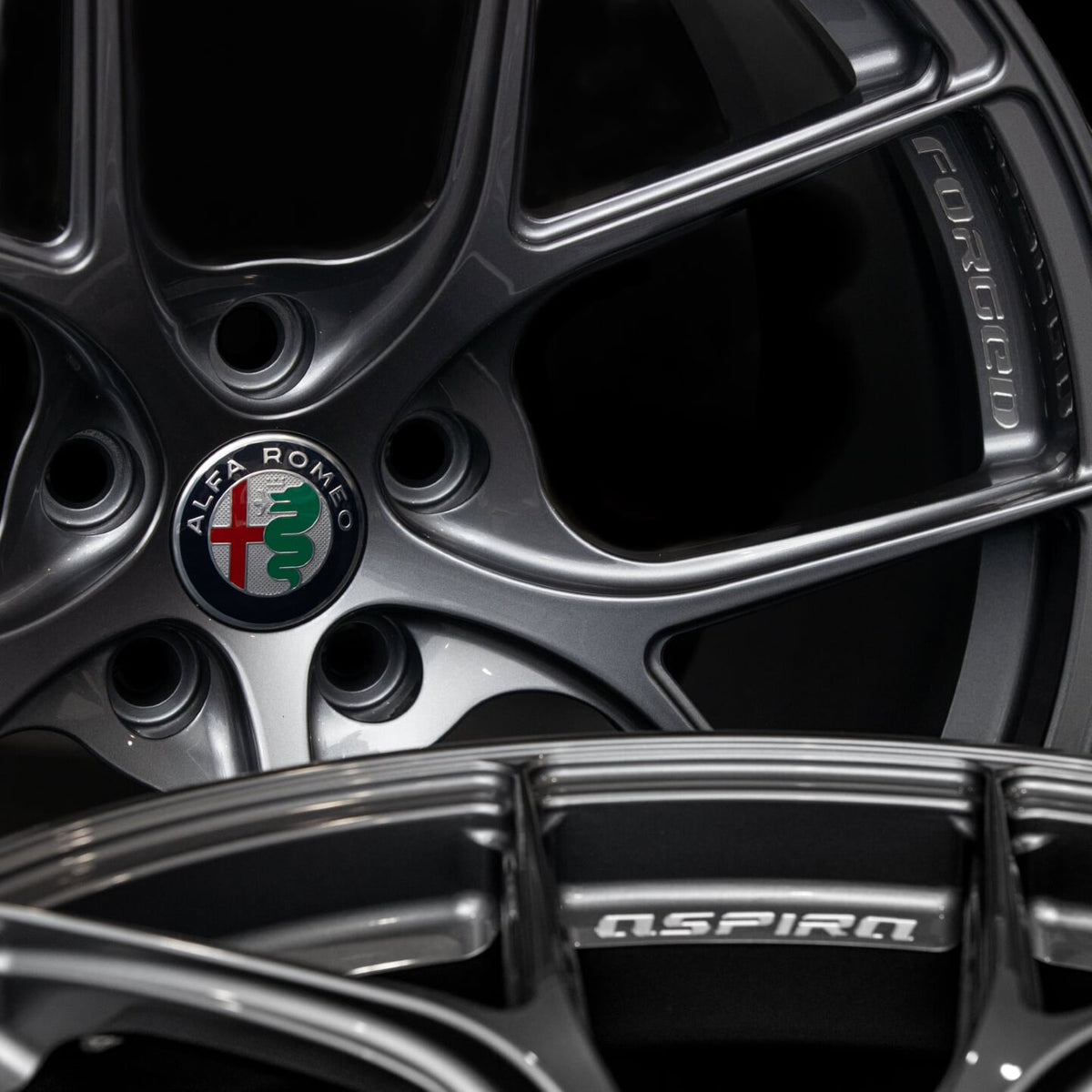 Aspira AV-5 gun metal close view of alfa romeo, aspira, and forged logo